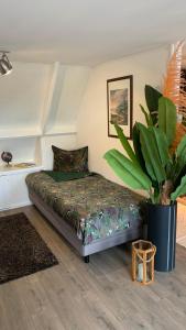 a bedroom with a bed and a potted plant at Cityhouse Vincent in Den Helder