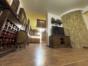a living room with a tv and a room with wine bottles at Vila IRA in Veria
