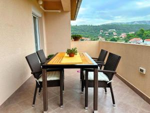 una mesa y sillas en un balcón con vistas en Apartman DUJAM, en Rab