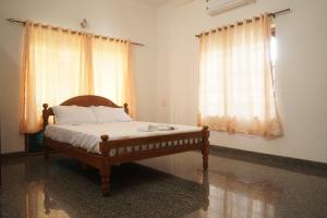sypialnia z łóżkiem i 2 oknami w obiekcie Joby homestay Kadamakudy w mieście Ernakulam