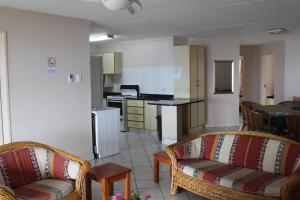 a living room with two couches and a kitchen at Anguna Holiday Flats in Margate