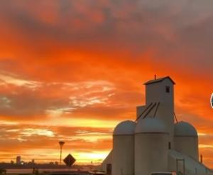 a white building with a sunset in the background at Apart Wilma in Encarnación