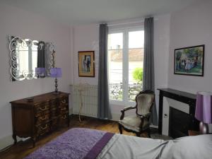 a bedroom with a bed and a desk and a window at Maison Carteret à 10 mn Lac du Der plages port casino confort et calme jardin bbq in Montier-en-Der