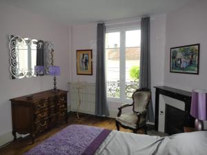 a bedroom with a bed and a desk and a window at La Maison Carteret in Montier-en-Der