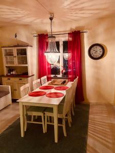 a dining room with a table and red curtains at Vindsvåning Höga Kusten in Kramfors