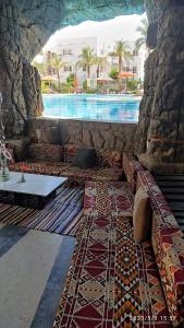 uma sala de estar com um sofá e uma piscina em OpenSpace 50 mq con Giardino em Sharm el Sheikh