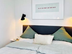 a bed with two pillows and a picture above it at Apartment Wendtorf XIX in Wendtorf