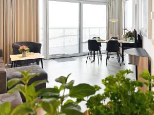 a living room with a table and chairs and a large window at Apartment Wendtorf XIX in Wendtorf