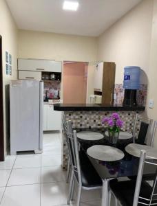a kitchen with a table with chairs and a refrigerator at Lençóis Dunas Residence 1 in Santo Amaro