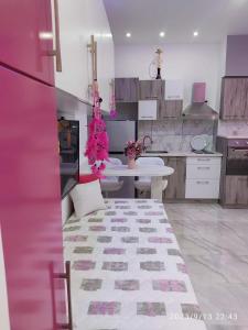 uma cozinha com uma mesa e uma cozinha rosa e branca em OpenSpace 50 mq con Giardino em Sharm el Sheikh