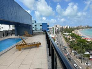 - un balcon dans un bâtiment avec une piscine et une ville dans l'établissement Neo 2.0, à Maceió