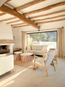een woonkamer met een bank en stoelen en een open haard bij Villa Azure 8p. - Zazu Villas in Girona