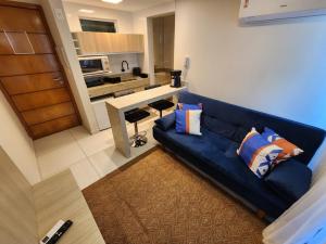 un soggiorno con un divano blu e una cucina di Tambaú Israel Flat 217 - Beira mar a João Pessoa Altre 26 foto
