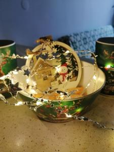 a teacup with christmas decorations in a bowl on a table at Fat Kaz Apartment in Wrocław