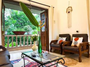 uma sala de estar com uma mesa de centro e uma varanda em NATURES HAVEN By Goaround Homes at Vagator em Vagator