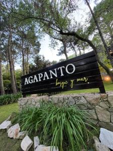 un panneau pour un parc avec un panneau pour le saut d'Acarronino et le chemin dans l'établissement Complejo Agapanto, à Mar de las Pampas