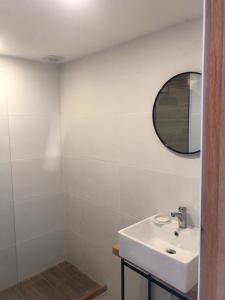 a white bathroom with a sink and a mirror at Rumah La Pedrera in La Pedrera
