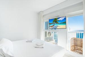 een witte kamer met een bed en een raam bij Veracruz 11-B Deluxe Apartment Levante Beach in Benidorm