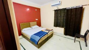 1 dormitorio pequeño con 1 cama y 1 silla en Prince Castle-4BHK Apartment,Guesthouse en Hyderabad