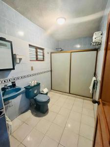 a bathroom with a blue toilet and a sink at Casa Limón, es tu casa, tu grande residencia in Calvillo