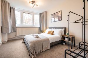 een hotelkamer met een bed en een raam bij Lovely 4 bedroom flat in Wandsworth- London in Londen