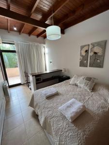 1 dormitorio con 1 cama con 2 almohadas en Complejo Agapanto en Mar de las Pampas