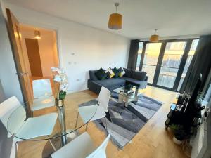 a living room with a couch and a table and chairs at Superb 1 Bedroom Serviced Apartment In City Centre in Birmingham