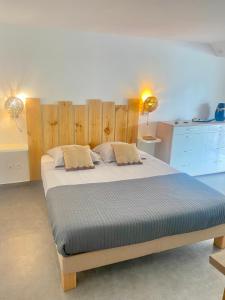 1 dormitorio con 1 cama grande y cabecero de madera en La Maison Calebasse en Saint-François
