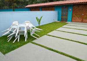a table and chairs sitting on the grass in a yard at Mare de Lua Boraceia in Boracéia