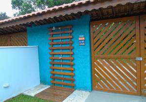 a house with a wooden gate and a blue wall at Mare de Lua Boraceia in Boracéia