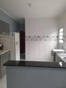 a kitchen with a counter top and a refrigerator at Casa de praia com piscina in Itanhaém