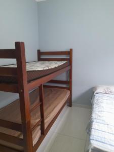 a bunk bed in a room next to a bed at Casa de praia com piscina in Itanhaém
