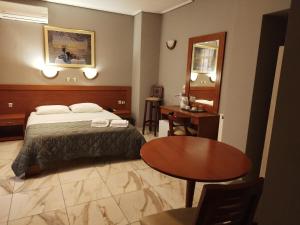 ピレウスにあるPiraeus Acropole Hotelのベッドとテーブルが備わるホテルルームです。