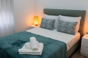 a bedroom with a bed with two towels on it at Cantinho do Avô Polaco in Nazaré +2 photos