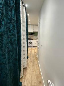 聖但尼的住宿－Cosy appartement / stade de France / portes paris，厨房的走廊上设有洗衣机和烘干机