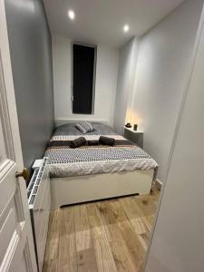 聖但尼的住宿－Cosy appartement / stade de France / portes paris，一间小房间的卧室,配有一张床铺
