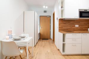 eine Küche und ein Esszimmer mit einem weißen Tisch und Stühlen in der Unterkunft Ski&Bike Apartmán Blue in Janské Lázně