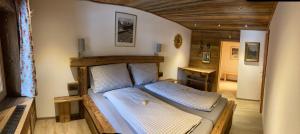 a bedroom with a wooden bed in a room at Öfnerhof in Leutasch