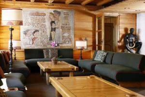 a living room with couches and tables and a mural at Hotel Corona in Cortina dʼAmpezzo