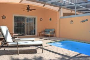 een patio met een zwembad met stoelen en een tafel bij TR1411RC - 3 Bedrooms - 3 Baths - Pool - Patio in Orlando