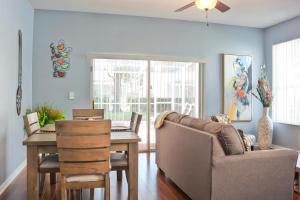 een woonkamer met een tafel, een stoel en een bank bij TR1411RC - 3 Bedrooms - 3 Baths - Pool - Patio in Orlando