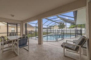 a patio with a table and chairs and a swimming pool at OT16029BH - 6 bedrooms - 12 guests in Orlando