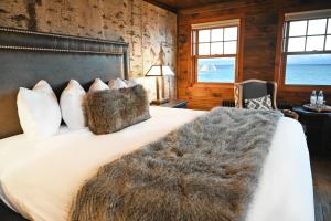 1 dormitorio con 1 cama grande con manta peluda en The Historic Lutsen Lodge, en Lutsen