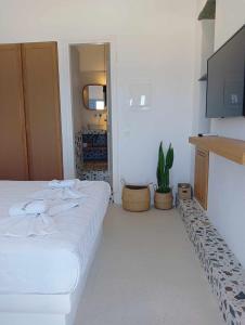 a bedroom with a bed and a flat screen tv at Anemousa Hotel in Chora Folegandros