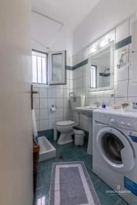 uma casa de banho com uma máquina de lavar roupa e um WC em Villa SK em Sissi