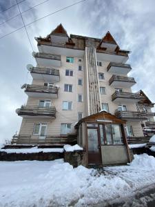 a large building with snow in front of it at Amazing flat in Gudauri, 5 minutes walk to slopes! in Kʼumlistsʼikhe