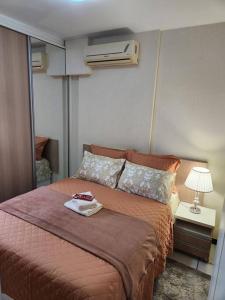 a bedroom with a bed with a pillow and a fan at Aconchegante apart no Park Sul in Brasilia