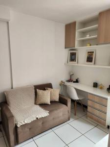 a living room with a couch and a desk at Aconchegante apart no Park Sul in Brasília