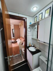a small bathroom with a bed and a sink at Aconchegante apart no Park Sul in Brasília