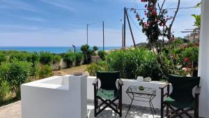 a table and chairs with a view of the ocean at Beachfront Oleanders House in Skala in Skala Kefalonias